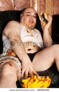 stock-photo-photo-of-a-man-sitting-in-a-big-chair-in-front-of-the-television-eating-a-hamburger-and-cheese-88986586